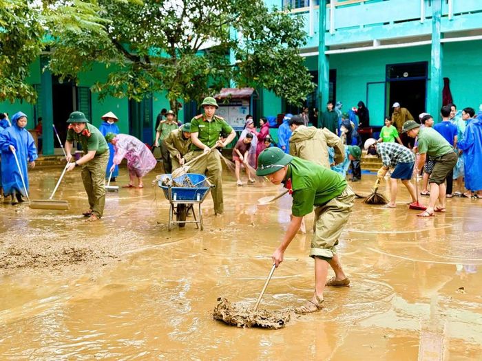 Dọn bùn non sau lũ để cô trò sớm trở lại trường học.