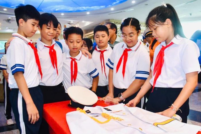  Các em học sinh tìm hiểu những tư liệu, hình ảnh về người chiến sĩ Hải quân nhân dân Việt Nam tại triển lãm. 