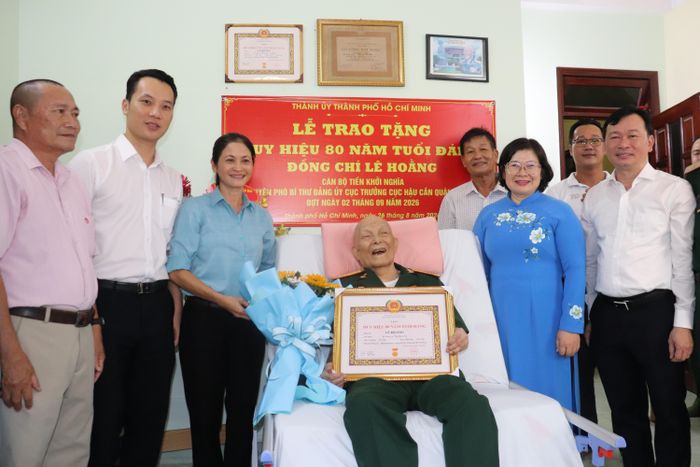  Phó Bí thư Thành ủy TPHCM Văn Thị Bạch Tuyết trao Huy hiệu 80 năm tuổi Đảng đến đồng chí Lê Hoằng. Ảnh: CẨM TUYẾT 