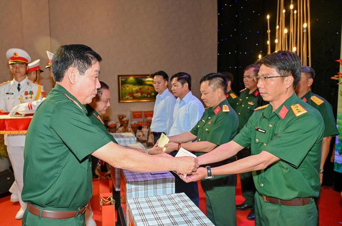  Thượng tướng Nguyễn Văn Gấu trao quà tặng các lực lượng làm nhiệm vụ tìm kiếm, quy tập hài cốt liệt sĩ. Ảnh: MẠNH THẮNG 
