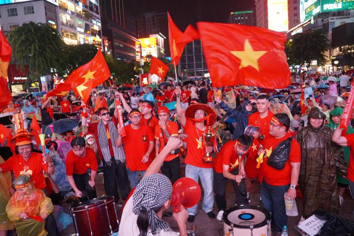 Cổ động viên rực sắc đỏ, đánh trống, thổi kèn và phất cờ cổ vũ đội tuyển Việt Nam