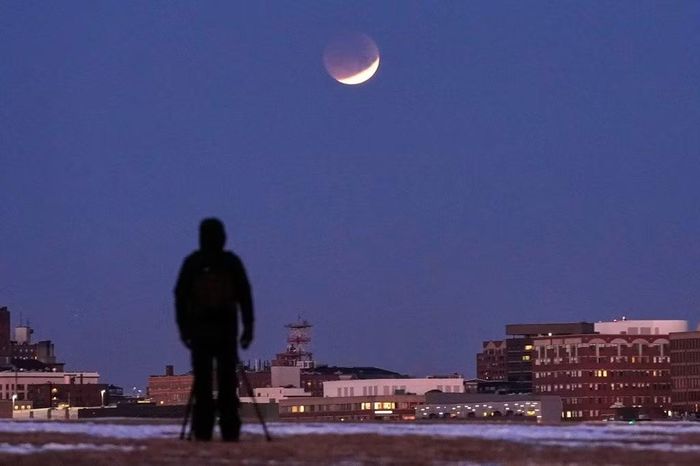 Người đàn ông quan sát hiện tượng nguyệt thực tại South Portland, Maine, Mỹ, ngày 3/3/2026. Ảnh: AP/Robert F. Bukaty.