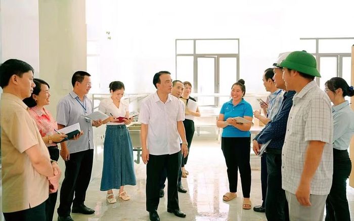 Ông Phạm Giang Nam - Giám đốc Sở Y tế Điện Biên (áo trắng, đứng giữa) cùng đoàn công tác của Sở Y tế làm việc với đơn vị trường học.