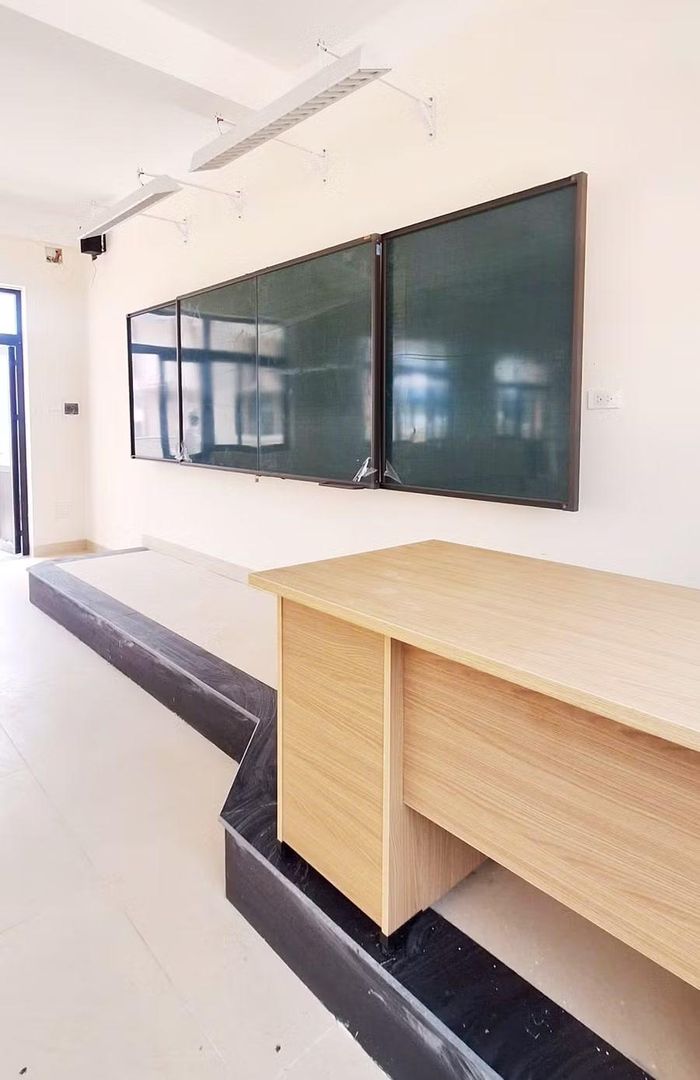Bục giảng của giáo viên và hệ thống bảng chống lóa hiện đại.