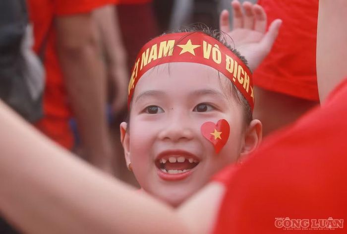 Tại khu vực bên ngoài sân, nhiều cổ động viên với gương mặt háo hức, vui vẻ, trên má dán cờ đỏ sao vàng được cắt hình trái tim.