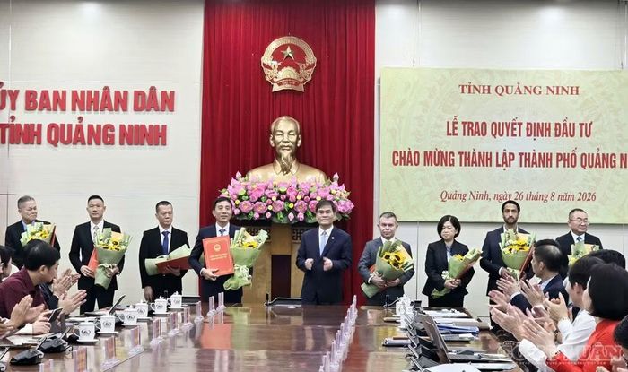 Chủ tịch UBND tỉnh Quảng Ninh trao quyết định đầu tư và tặng hoa chúc mừng đại diện các doanh nghiệp, nhà đầu tư tại hội nghị vào chiều 26/8.