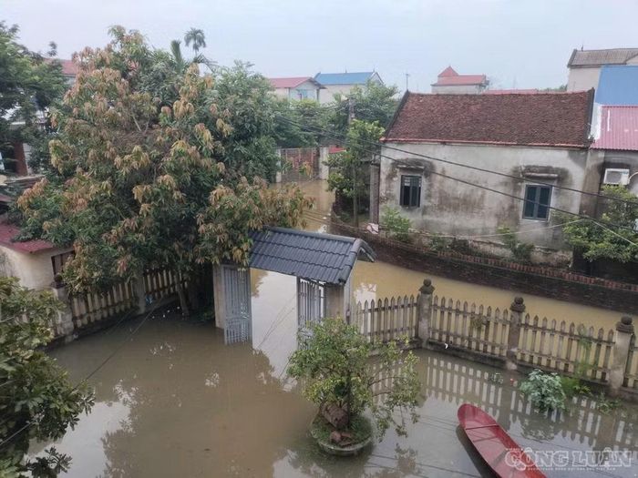 Nước ngập bủa vây nhà dân ở thôn An Lạc, xã Trung Giã. Ảnh: C.H