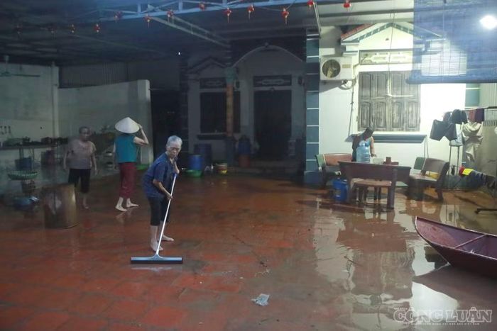 Bà Cao Thị Thu, 75 tuổi, cùng nhiều người trong gia đình đang dọn dẹp nhà cửa khi nước bắt đầu rút.