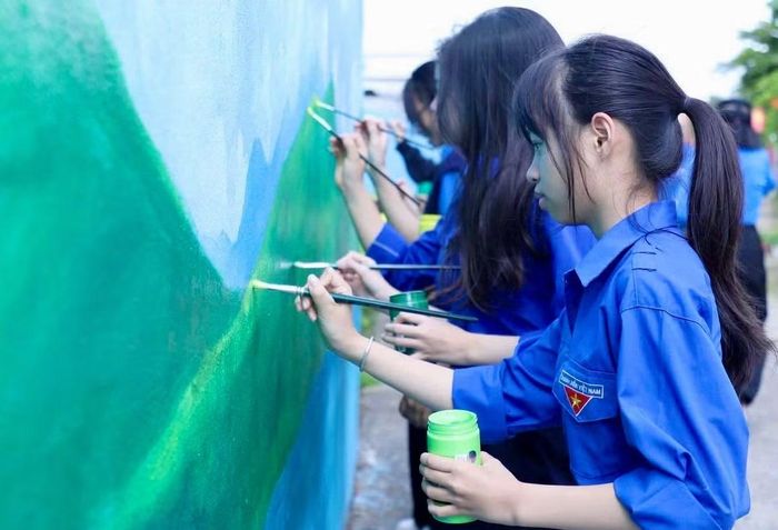 Các đại biểu, đoàn viên thanh niên vẽ tường bích họa.