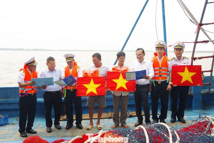Trao tặng cờ Tổ quốc, áo phao cho bà con ngư dân.