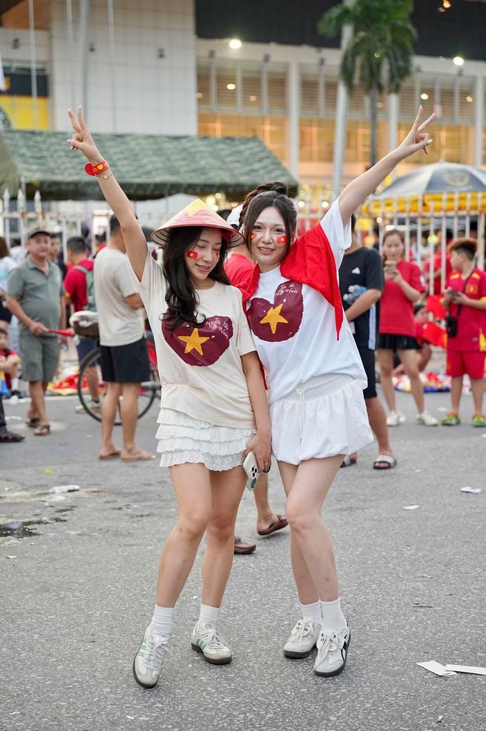 Hai nữ cổ động viên lựa chọn áo in hình ngôi sao vàng, kết hợp nón lá và cờ Tổ quốc. Sau chiến thắng 2-0 ở lượt đi, tuyển Việt Nam chỉ cần không thua với cách biệt quá một bàn trong trận lượt về để giành chức vô địch.