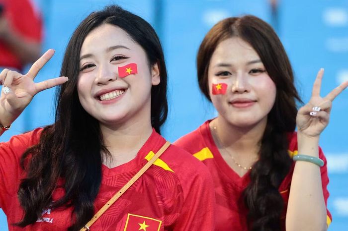 Hai nữ cổ động viên dán hình quốc kỳ lên má, vui vẻ tạo dáng trước giờ thi đấu. Ở trận lượt đi ngày 22/8, Hai Long và Quang Hải cùng lập công, giúp Việt Nam thắng Thái Lan 2-0 ngay trên sân Rajamangala.