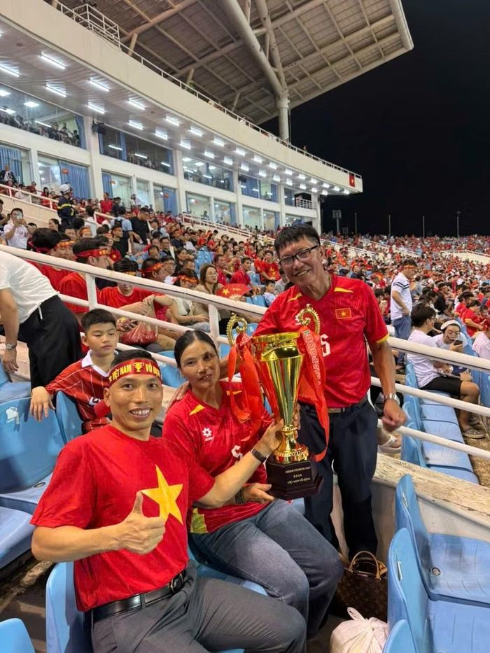 Ông Đoàn Quốc Thắng và bà Đỗ Thị Nụ, bố mẹ Đoàn Văn Hậu, cùng các thành viên trong gia đình có mặt tại Hà Nội từ sáng sớm 26/8. Cả gia đình mặc áo đỏ, mang theo mô hình chiếc cúp lên khán đài, kỳ vọng Văn Hậu và đồng đội duy trì lợi thế hai bàn để bảo vệ chức vô địch ASEAN Cup.