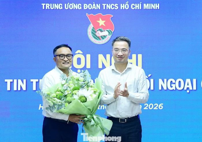 Anh Nguyễn Tường Lâm tặng hoa PGS.TS Lê Đình Tĩnh - diễn giả chia sẻ nội dung tại chương trình. Ảnh: Xuân Tùng