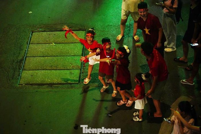 Hai bên đường cũng được phủ kín. Cổ động viên nhí theo cha mẹ hòa chung không khí ăn mừng.