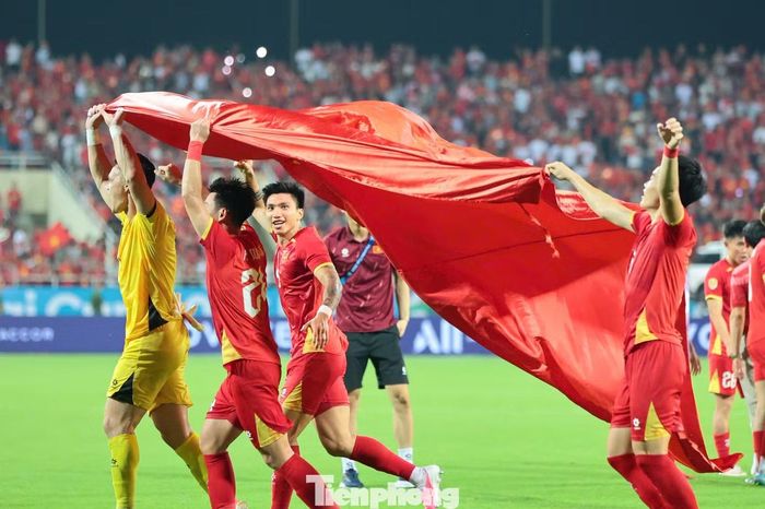 Sau hơn 90 phút căng thẳng, các tuyển thủ áo đỏ ôm nhau ăn mừng và mang quốc kỳ ra sân.