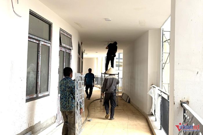 Một số công nhân đang thi công hành lang phòng học của khối tiểu học. Ảnh: NKH