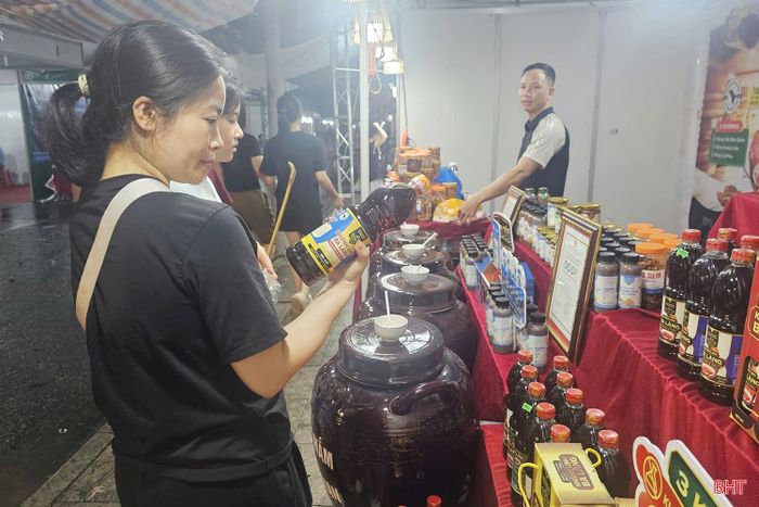 Người dân tìm hiểu sản phẩm nước mắm truyền thống tại gian hàng của cơ sở nước mắm Khánh Linh Ba Làng.