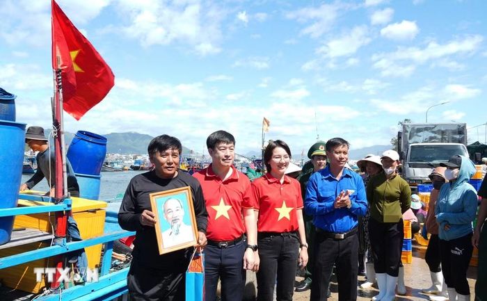 Ban tổ chức Hành trình “Tôi yêu Tổ quốc tôi” năm 2026 tặng quà, Cờ Tổ quốc và ảnh Bác Hồ cho ngư dân ở cảng cá dân sinh phường Nam Nha Trang, tỉnh Khánh Hòa. (Ảnh: Phan Sáu/TTXVN)