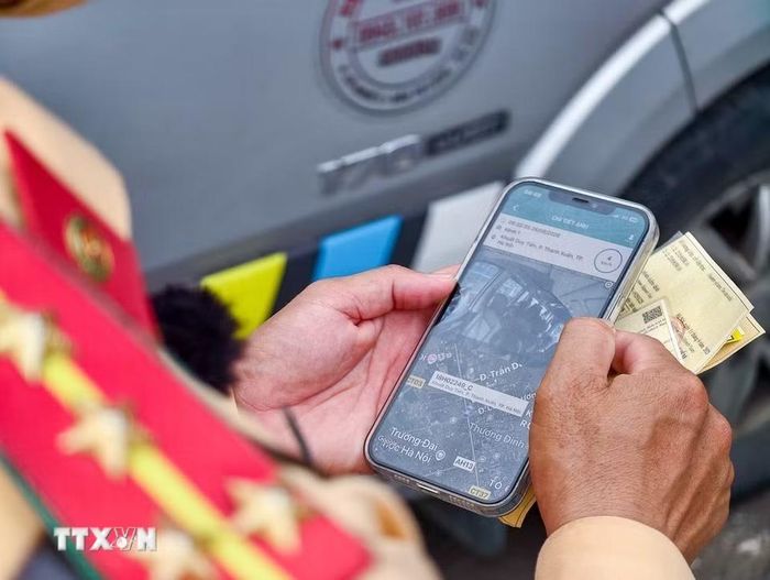 Lực lượng Cảnh sát giao thông đối chiếu thông tin phương tiện, giấy tờ và dữ liệu phục vụ công tác kiểm tra. (Ảnh: Trung Nguyên/TTXVN)