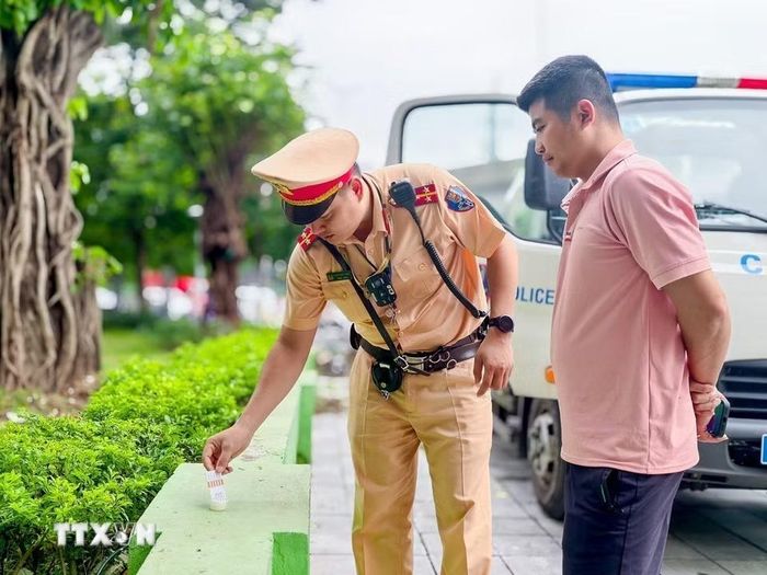 Lực lượng Cảnh sát giao thông thực hiện test nhanh ma túy đối với lái xe kinh doanh vận tải trên tuyến Khuất Duy Tiến. (Ảnh: Trung Nguyên/TTXVN)