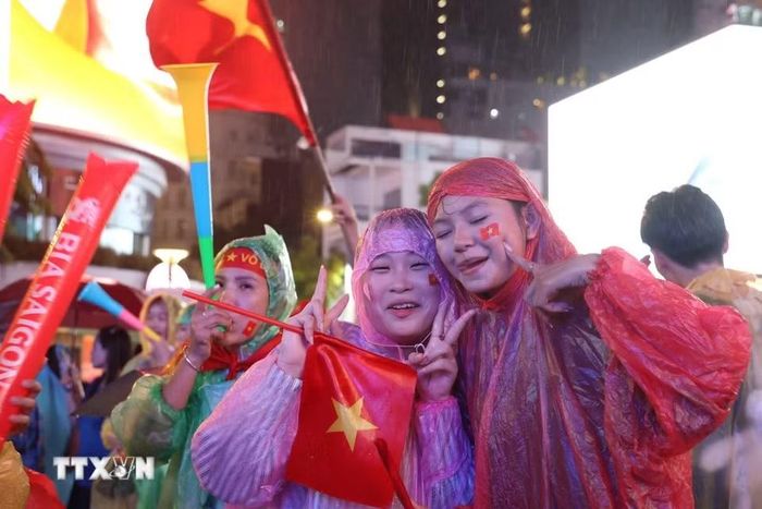 Người hâm mộ Thành phố Hồ Chí Minh đội mưa chờ đợi Việt Nam vô địch bóng đá Đông Nam Á lần thứ 4. (Ảnh: Hồng Đạt/TTXVN)