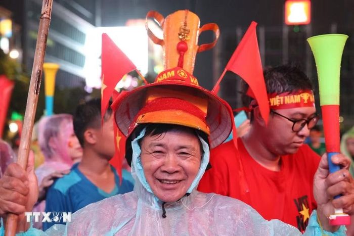 Cổ động viên trong trang phục mang sắc đỏ, sẵn sàng tiếp lửa đội tuyển Việt Nam. (Ảnh: Hồng Đạt/TTXVN)
