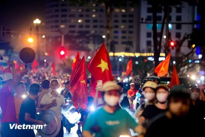 Những tiếng còi xe, tiếng kèn vuvuzela kết hợp cùng tiếng gõ mâm, gõ xoong chảo rộn rã tạo nên một bản hòa ca cuồng nhiệt vang vọng cả đêm đen. (Ảnh: Hoài Nam/Vietnam+)