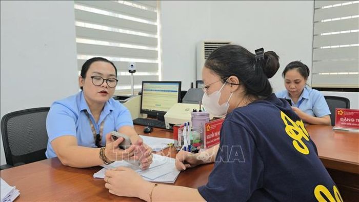 Công chức phường Mạo Khê hướng dẫn công dân nộp hồ sơ chứng thực lên Cổng dịch vụ công Quốc gia. Ảnh tư liệu: Thanh Vân/TTXVN