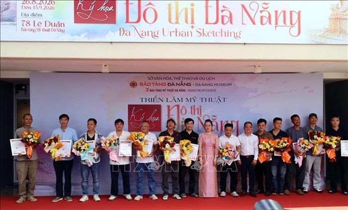 Các họa sĩ có tác phẩm tham dự triển lãm nhận hoa chúc mừng của Ban tổ chức tại triển lãm.
