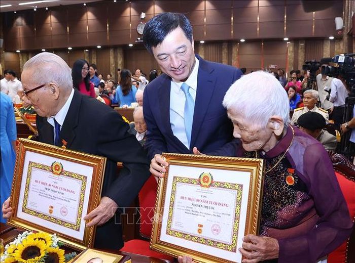 Đồng chí Nguyễn Duy Ngọc, Ủy viên Bộ Chính trị, Bí thư Trung ương Đảng, Trưởng Ban Tổ chức Trung ương trao Huy hiệu Đảng, chúc mừng các đảng viên lão thành. Ảnh: Văn Điệp/TTXVN