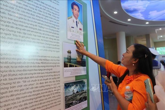Bà Vũ Thị Phương (em gái Anh hùng LLVTND - Liệt sĩ Vũ Quang Chương) nghẹn ngào xúc động khi xem lại hình ảnh, kỷ vật của người anh trai tại không gian trưng bày.
