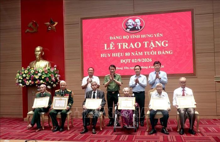 Đại tướng Lương Tam Quang, Ủy viên Bộ Chính trị, Bộ trưởng Bộ Công an và lãnh đạo tỉnh Hưng Yên chúc mừng các đảng viên nhận Huy hiệu 80 năm tuổi Đảng. Ảnh: Đinh Văn Nhiều/TTXVN