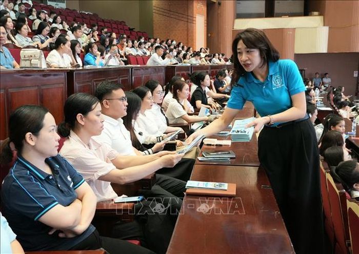 Cán bộ Bảo hiểm xã hội tỉnh Bắc Ninh phát tài liệu tuyên truyền, phổ biến chính sách bảo hiểm xã hội, bảo hiểm y tế cho đại diện các doanh nghiệp tham dự Hội nghị.