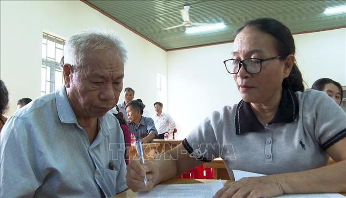Thành viên Tổ hỗ trợ trực tiếp hướng dẫn người dân hoàn thiện hồ sơ, thủ tục cấp Giấy chứng nhận quyền sử dụng đất lần đầu tại khu dân cư.