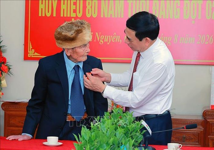 Đại tướng Phan Văn Giang, Ủy viên Bộ Chính trị, Phó Thủ tướng Chính phủ, Bộ trưởng Bộ Quốc phòng trao Huy hiệu 80 năm tuổi Đảng cho ông Nguyễn Quang Nam, phường Vạn Xuân. Ảnh: Trần Trang/TTXVN