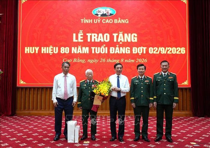 Đại tướng Phan Văn Giang trao tặng Huy hiệu 80 năm tuổi Đảng và chúc mừng đồng chí Nguyễn Khánh Trung. Ảnh: Chu Hiệu/TTXVN