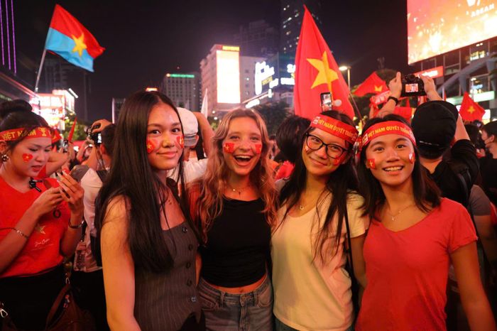 Du khách quốc tế và người hâm mộ Việt Nam hào hứng hòa vào dòng người ăn mừng tại trung tâm TP Hồ Chí Minh.