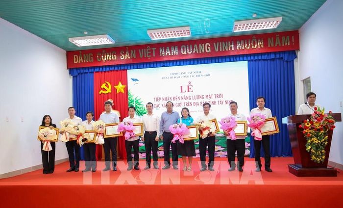 Đại diện các tập thể, cá nhân nhận Bằng khen của Chủ tịch UBND tỉnh Tây Ninh vì có thành tích đóng góp kinh phí thực hiện Chương trình “Chung tay thắp sáng biên giới”. Ảnh: Giang Phương - TTXVN