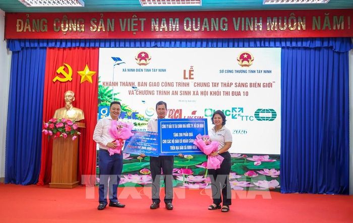 Đại diện các đơn vị trao biểu trưng tài trợ Chương trình khám bệnh, phát thuốc và tặng 200 phần quà cho người dân thuộc hộ nghèo, có hoàn cảnh khó khăn tại xã Ninh Điền, tỉnh Tây Ninh. Ảnh: Giang Phương - TTXVN