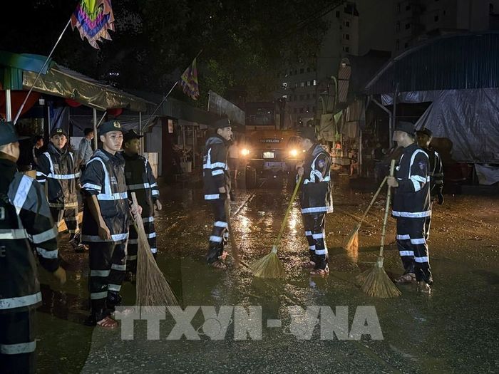 Cán bộ, chiến sĩ tổ chức quét dọn trong chợ Giếng Vuông, tỉnh Lạng Sơn. Ảnh: Tiến Vĩnh – TTXVN
