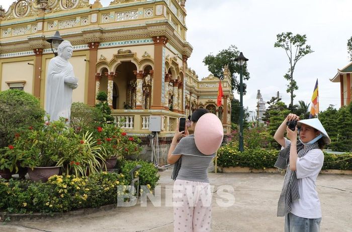 Du khách ghi lại hình ảnh kiến trúc chùa Vĩnh Tràng (phường Mỹ Phong). Ảnh: Hồng Thái-TTXVN