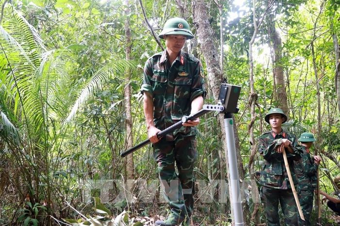 Bộ đội Công binh rà bom mìn, đảm bảo an toàn trước khi tìm kiếm, cất bốc hài cốt liệt sĩ. Ảnh: Xuân Triệu - TTXVN