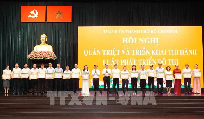 Lãnh đạo TP. Hồ Chí Minh trao Bằng khen cho các đơn vị có thành tích trong công tác tham mưu, xây dựng và chuẩn bị triển khai thi hành Luật Phát triển đô thị. Ảnh: Trung Tuyến - TTXVN
