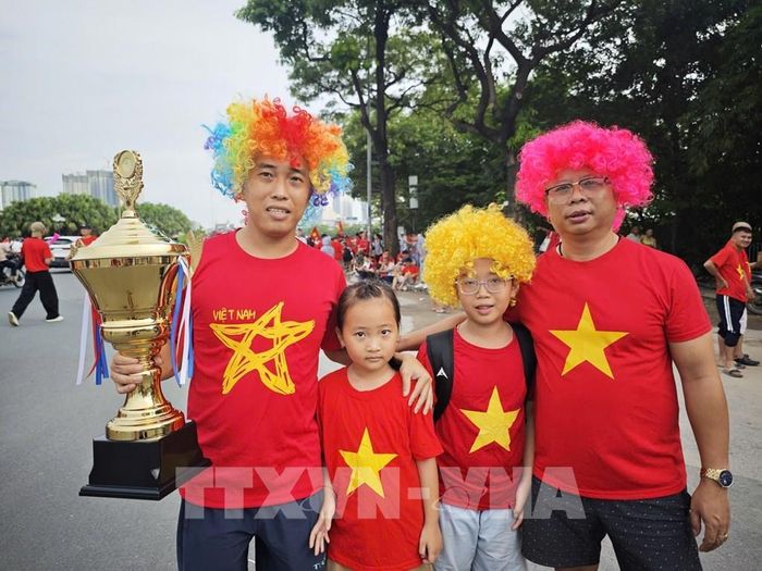 Các cổ động viên cầm trên tay phiên bản cúp vàng để cổ vũ cho chiến thắng của đội nhà. Ảnh: Nam Sương - TTXVN