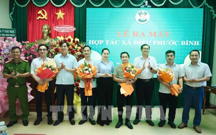 Lãnh đạo phương Phước Bình tặng hoa chúc mừng tập thể Hợp tác xã Điều Phước Bình. Ảnh: K GỬIH -TTXVN