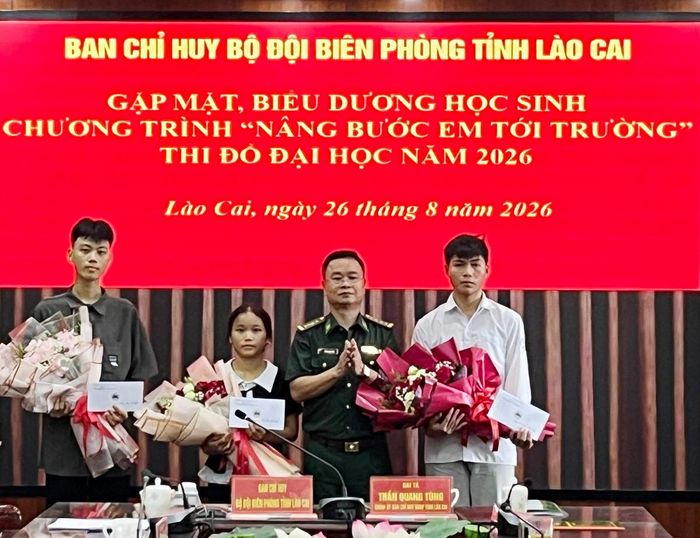 Đại tá Trần Quang Tùng, Chính ủy BĐBP tỉnh Lào Cai, tặng hoa chúc mừng các em đỗ đại học