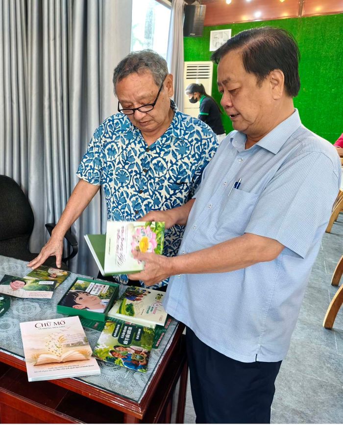 Ông Lê Minh Hoan giới thiệu một số sách mới với nhà báo Trần Trung Chính (Phó Viện trưởng Viện Nghiên cứu đô thị và Phát triển hạ tầng; thường trực Ban tư vấn Người Đô Thị). Ảnh: Trung Dũng