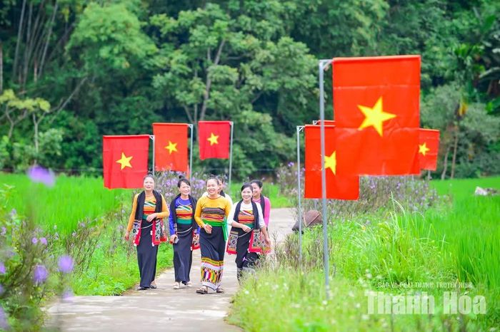 Những cô gái Thái trong trang phục truyền thống xuất hiện bên đường cờ, mang theo vẻ đẹp mộc mạc của con người và văn hóa vùng cao xã Nam Xuân.