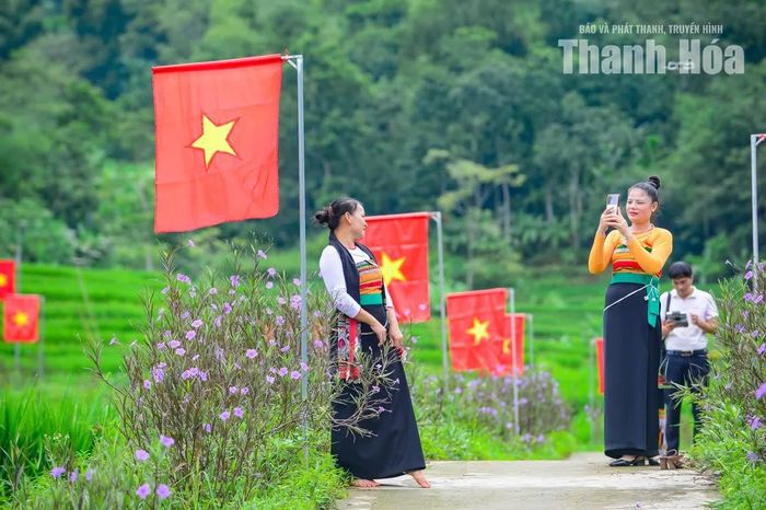 Giữa sắc đỏ của cờ sao vàng, núi rừng xanh ngát và những thửa ruộng bậc thang yên bình, người dân và du khách thích thú chụp ảnh, lưu lại những khoảnh khắc đặc biệt nơi vùng cao.